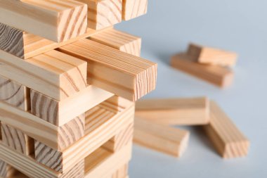 Gri arka planda tahta bloklardan yapılmış Jenga kulesi, yakın plan. Metin için boşluk