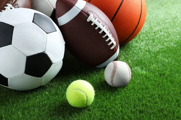 緑の芝生の上で異なるスポーツボールのセット — ストック写真