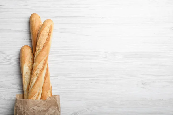 Baguettes Savoureuses Paquet Sur Table Bois Blanc Vue Sur Dessus — Photo