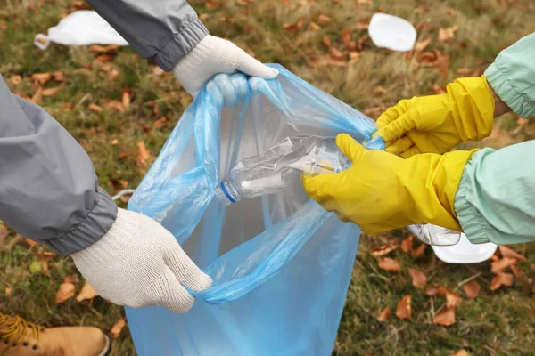 ゴミ袋を持った人が自然ゴミを集めたり閉じたり — ストック写真