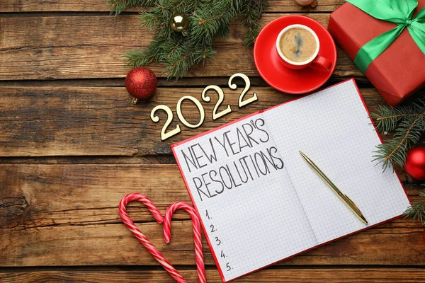 制定2022年新年的决议 在木制桌子上铺有笔记本和节日装饰的平面构图 — 图库照片