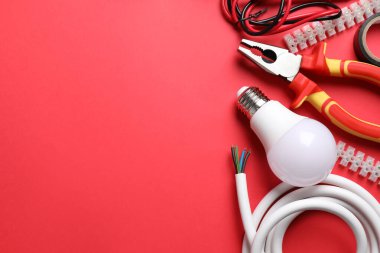 Kırmızı arka planda elektrikli aletler ve aksesuarlar var. Metin için boşluk