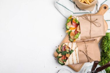 Tavuk ve taze sebzeli nefis shawarmalar beyaz masada, düz yerde. Metin için boşluk