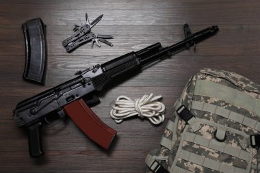 Düz kompozisyon, silah ve askeri çanta ile ahşap masa üzerinde yatıyordu.