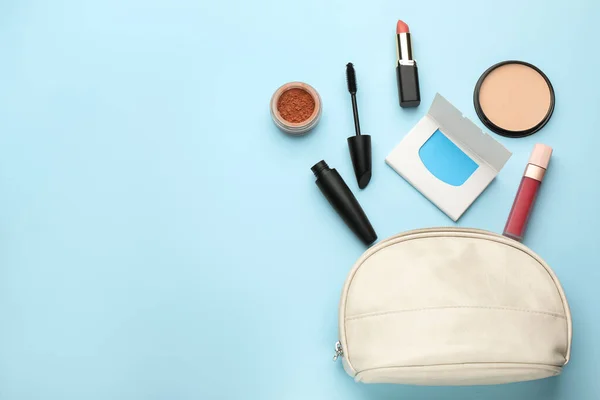 Flat lay composition with facial oil blotting tissues and makeup products on light blue background, space for text. Mattifying wipes