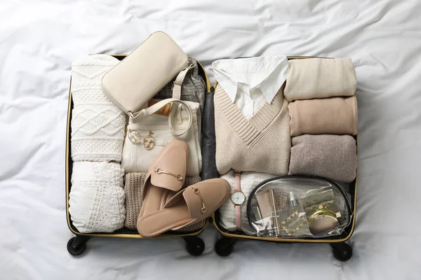 Nyitott Bőrönd Összecsukható Ruhákkal Cipőkkel Kiegészítőkkel Ágyon Felülnézet — Stock Fotó