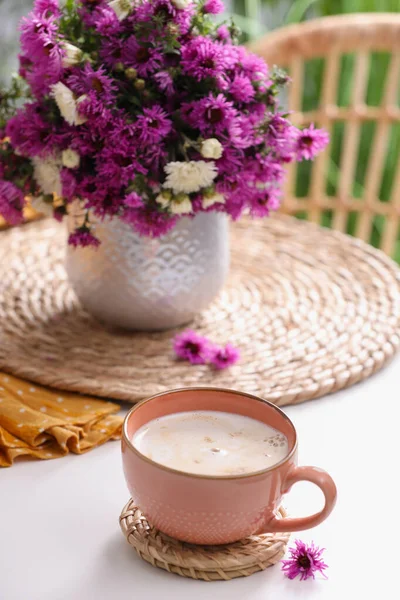 一杯芬芳的咖啡和白桌上美丽的花朵 — 图库照片