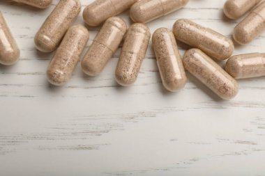 Beyaz ahşap masadaki jelatin kapsüller düz. Metin için boşluk