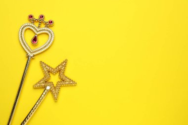 Sarı arka planda güzel altın sihirli değnekler, düz bir zemin. Metin için boşluk