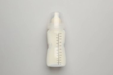 Işık arka planında bebek mamasıyla beslenme şişesi, üst görünüm