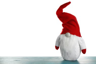 Turkuaz ahşap masada beyaz arka planda komik bir noel cücesi. Metin için boşluk