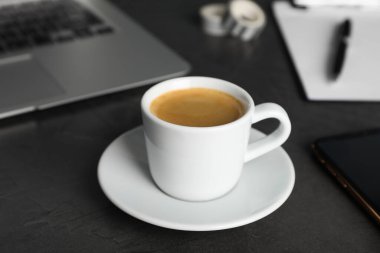İş yerinde kahve molası. Gri masada bir fincan sıcak espresso.