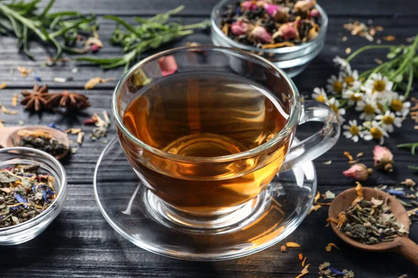 Taze Demlenmiş Çay Siyah Ahşap Masa Üzerindeki Farklı Yapraklarla Kompozisyon — Stok fotoğraf