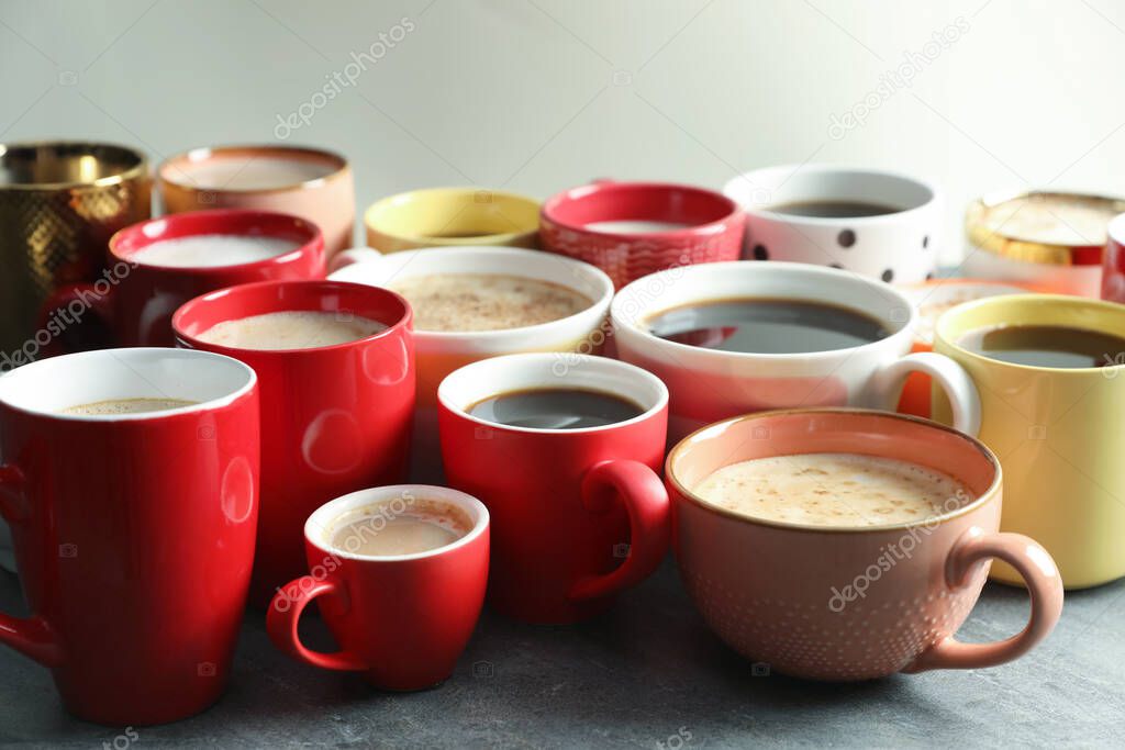 Many cups of different coffees on grey table