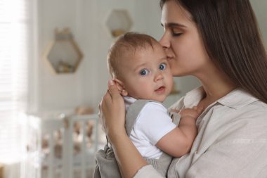 Bebek odasında bebeğiyle mutlu genç bir anne. Metin için boşluk