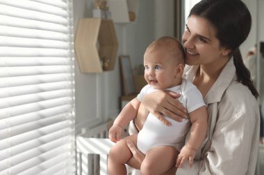 Evinin penceresinin yanında bebeğiyle mutlu bir anne. Metin için boşluk