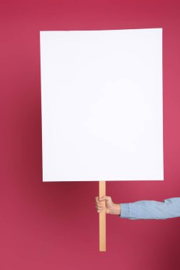 Pembe arka planda boş tabela tutan kadın, yakın plan. Tasarım için boşluk