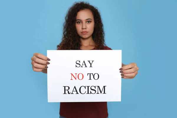 アフリカ系アメリカ人の女性は 光の青を背景に人種差別にノーと言います 手に焦点を当てます — ストック写真