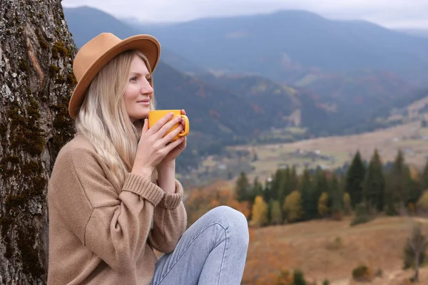 山の中で熱い飲み物のマグカップを持つ若い女性 テキストのスペース — ストック写真
