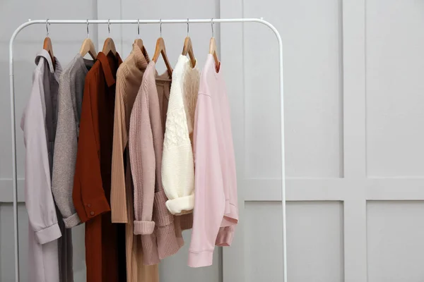 Rack Met Verschillende Stijlvolle Kleding Buurt Van Grijze Muur Ruimte — Stockfoto