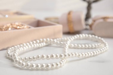 Beyaz mermer masa üzerinde şık bijouterie, yakın çekim görünümü