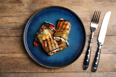 Tahta masada servis edilen nefis fırınlanmış patlıcan ruloları.