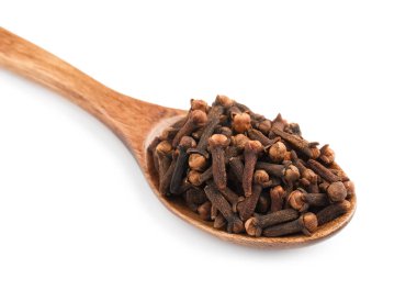 Tahta kaşık aromalı kuru karanfiller beyaz üzerine izole edilmiş, yakın plan