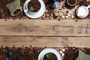 Düz kompozisyon ve kavrulmuş kahve çekirdekleri ahşap masada. Metin için boşluk