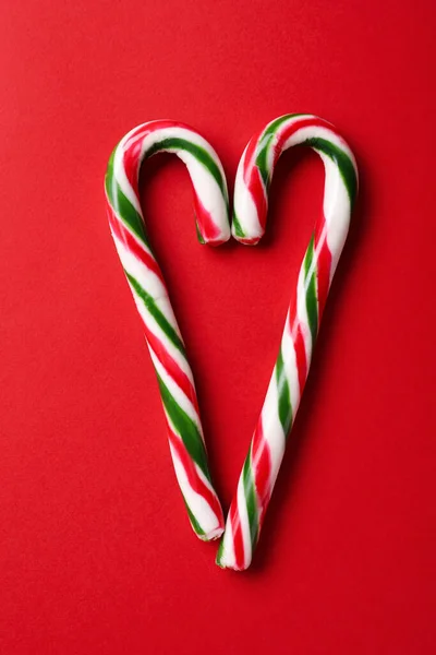 Kırmızı Arka Planda Noel Şeker Kamışlarından Yapılmış Kalp Düz Yatıyordu — Stok fotoğraf