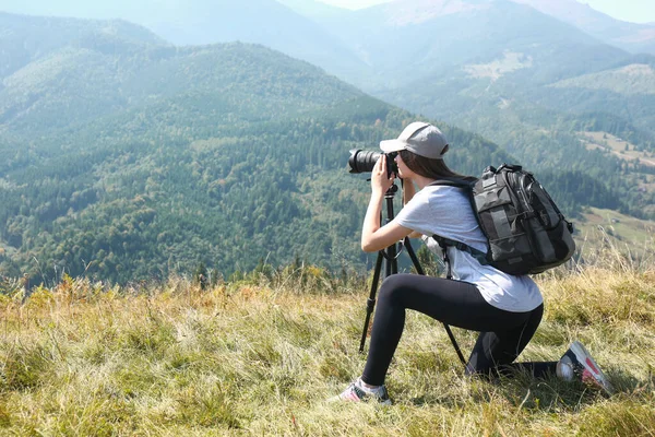 三脚で現代的なカメラで山の風景の写真を撮る女性屋外 — ストック写真