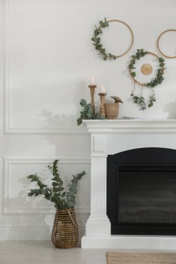 Güzel şömineli ve okaliptüs dallı şık bir oda.