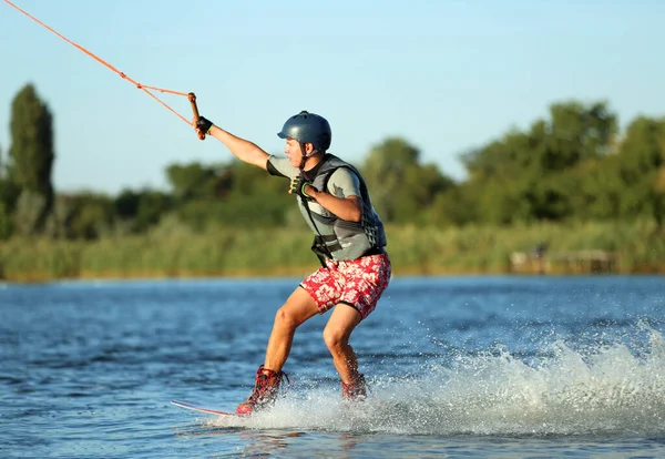 Genç çocuk nehirde wakeboard yapıyor. Aşırı su sporu