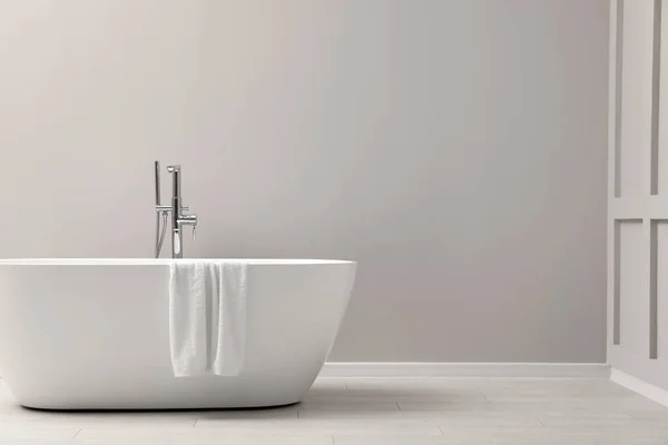 Moderne Keramik Badewanne Mit Handtuch Der Nähe Der Lichtwand Innenraum — Stockfoto