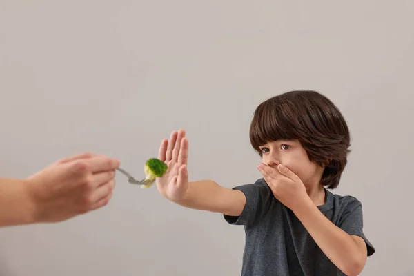 Carino Ragazzino Che Copre Bocca Rifiuta Mangiare Broccoli Sfondo Grigio — Foto Stock