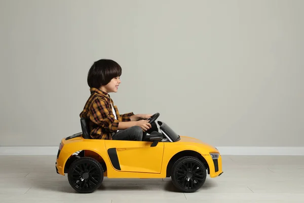 Lindo Niño Conduciendo Coche Juguete Eléctrico Para Niños Cerca Pared —  Fotos de Stock