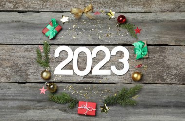 2023 numaralı düz kompozisyon ve ahşap arka planda şenlikli dekor. Mutlu yıllar.