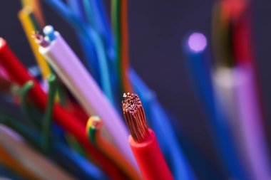 Arka plandaki renkli kablolar bulanık, yakın plan. Elektrikçi malzemesi.