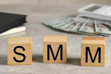 Gri taş masada SMM harfli tahta küpler.