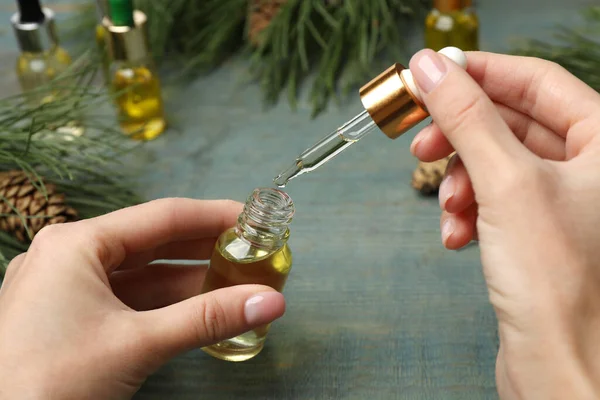 Mujer Sosteniendo Botella Con Aceite Esencial Pino Mesa Madera Azul — Foto de Stock