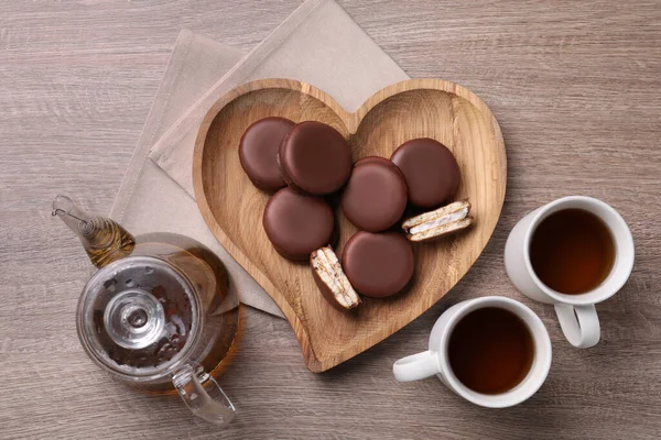 木製のテーブルの上においしいチョコパイとお茶 フラットレイアウト — ストック写真