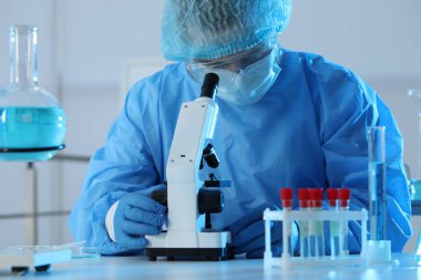 Laboratuvarda mikroskopla çalışan bir bilim adamı. Tıbbi araştırma