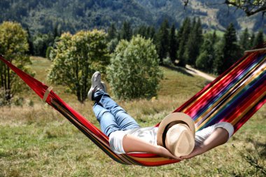Güneşli bir günde hamakta dinlenen bir adam.
