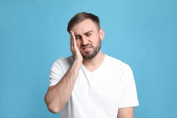 Giovane Uomo Che Soffre Mal Testa Sfondo Azzurro — Foto Stock