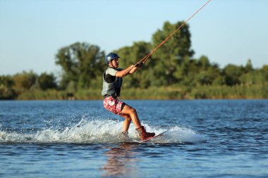 Genç çocuk nehirde wakeboard yapıyor. Aşırı su sporu