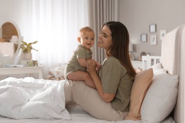 Mutlu bir genç anne ve tatlı bebeği evde yatıyor.