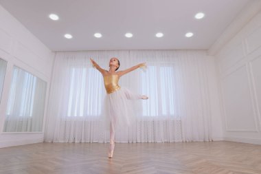 Stüdyoda dans eden güzel giyimli küçük balerin.