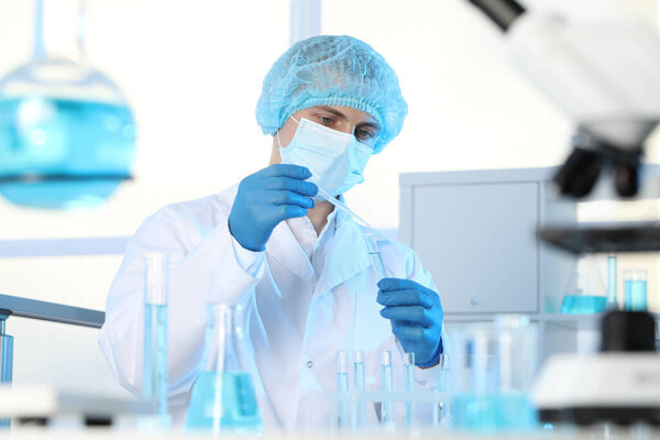 Scientist dripping sample into test tube in laboratory. Medical research