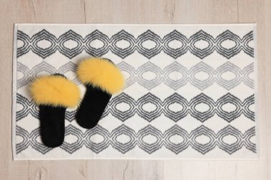 Yumuşak banyo paspası ve yerde terlikler, üst manzara.