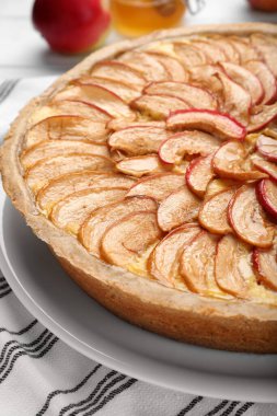 Beyaz çizgili masa örtüsü üzerinde lezzetli elmalı turta, yakın plan.