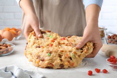 Beyaz masada Stollen için şekerli meyve ve fındıklı hamur yoğuran kadın, yakın plan. Geleneksel Alman Noel ekmeği pişiriyorum.